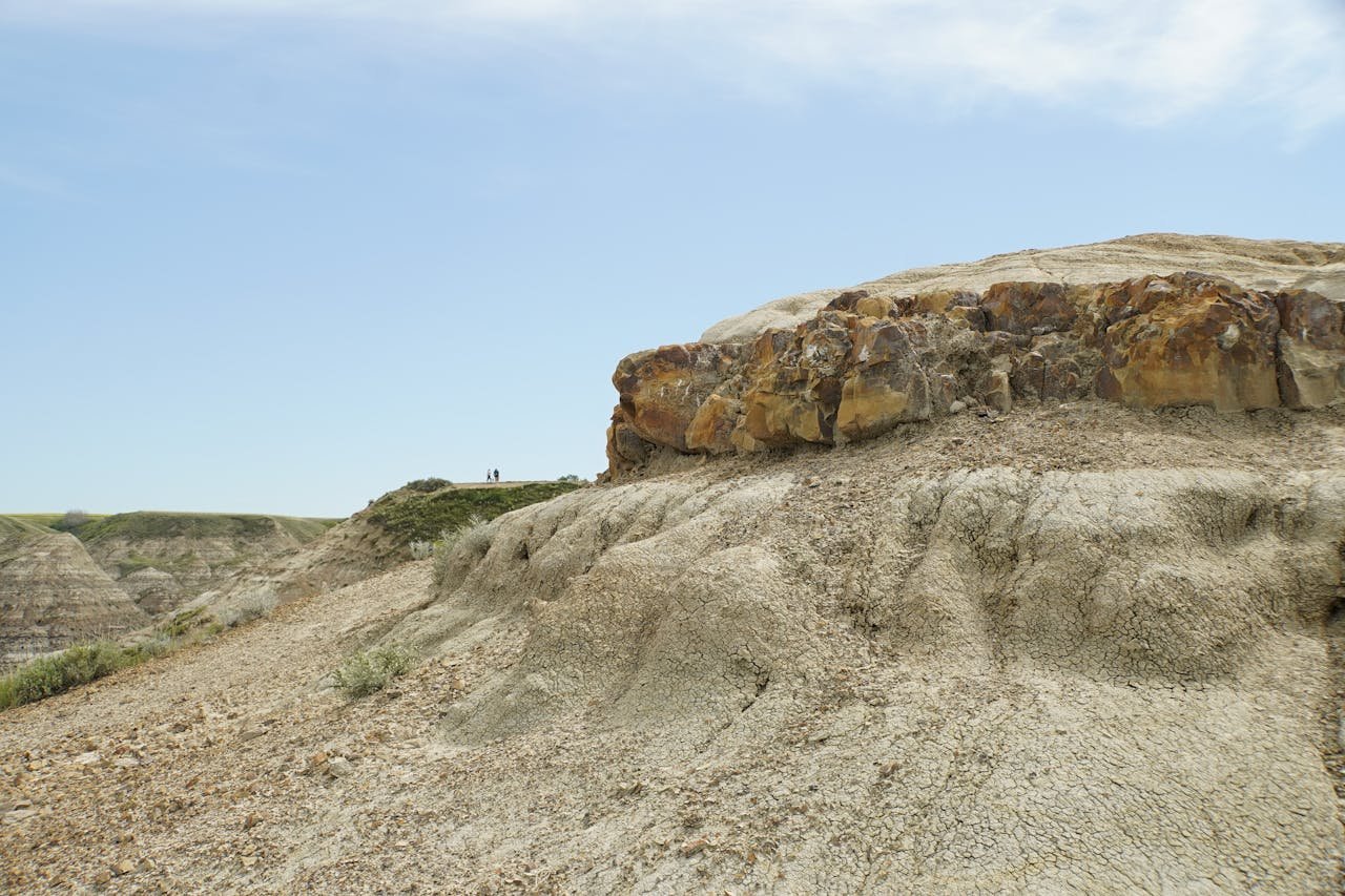Explore the rugged terrain of the Badlands with stunning geological formations under a clear blue sky.