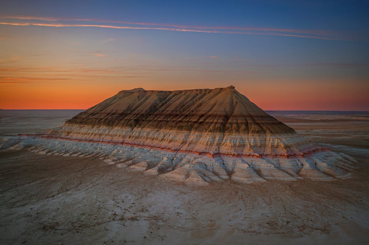 Scenic view of Mangystaus unique rock formation at sunset, showcasing vibrant colors and dramatic landscapes.